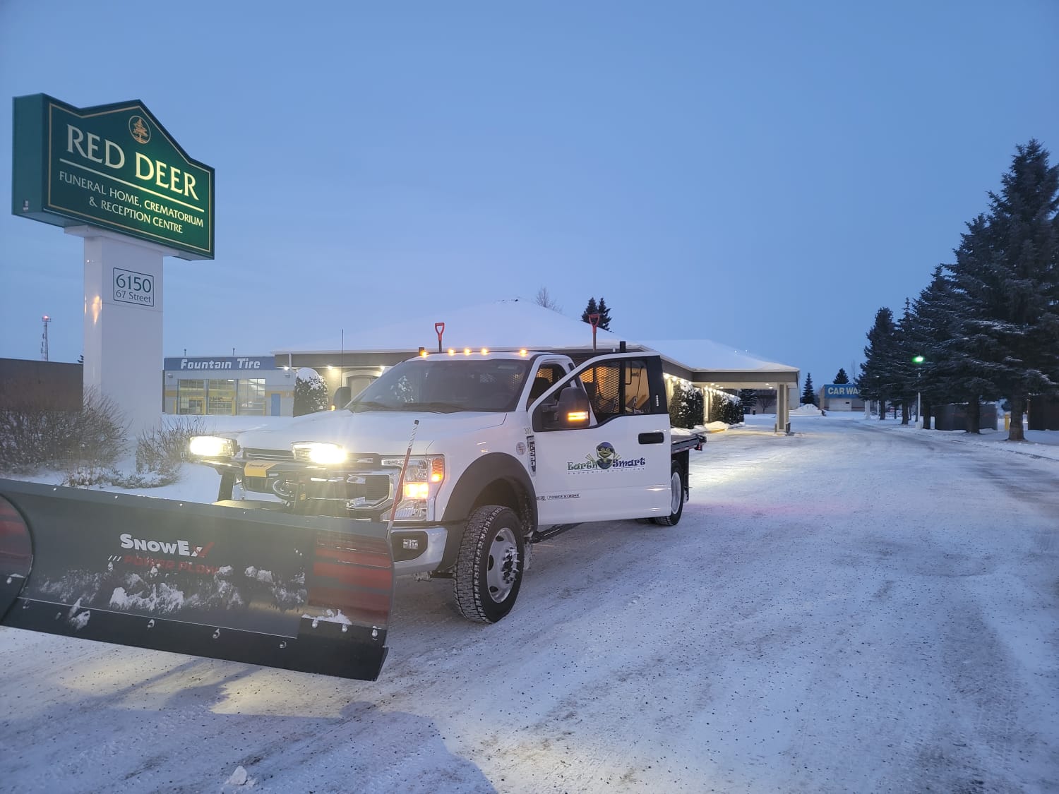 Truck with snow plow on commercial site
