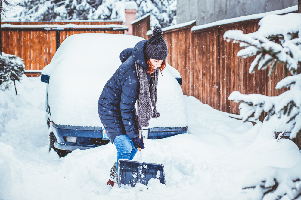 lady shoveling snow off the driveway