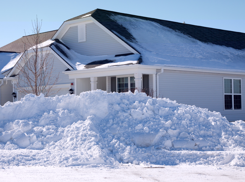 Large pile of snow in front of a house